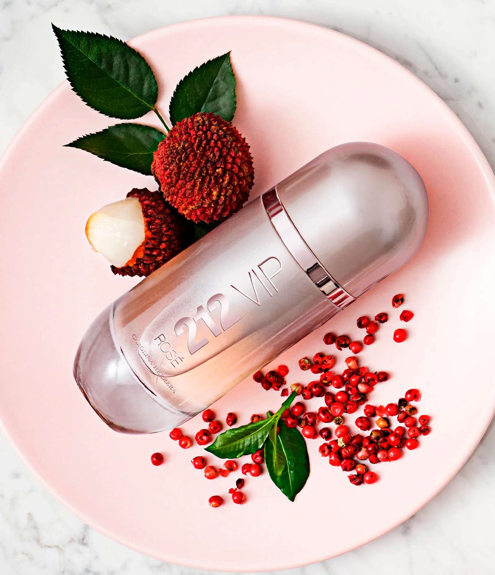 Frasco do perfume Carolina Herrera 212 VIP Rosé sobre superfície clara com fundo elegante, iluminado suavemente para destacar seu tom rosé metálico e design sofisticado.