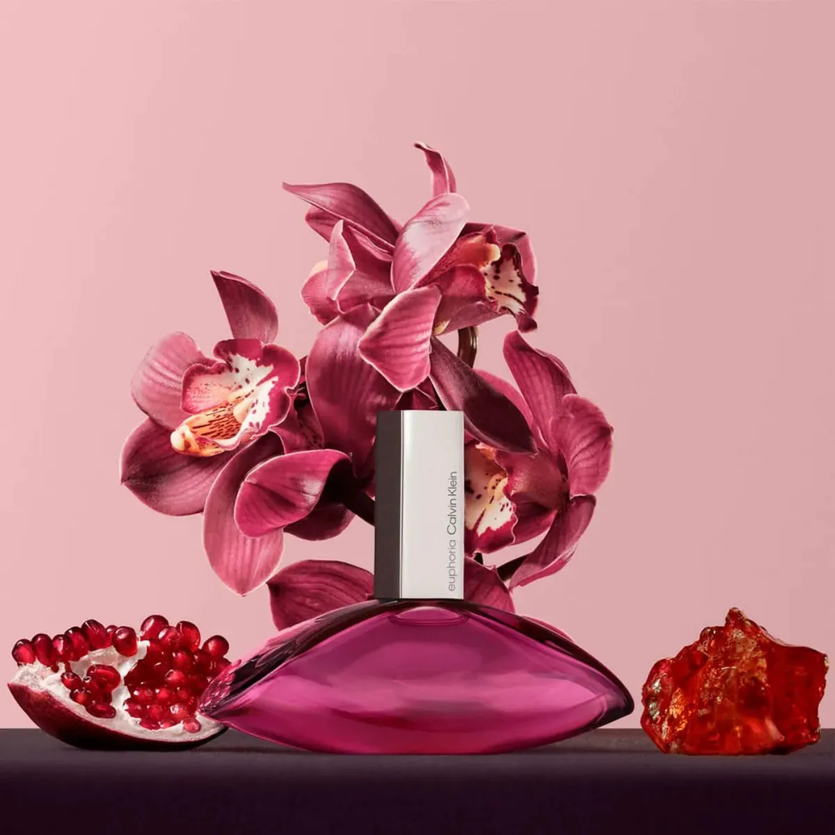 Frasco do perfume Calvin Klein Euphoria sobre fundo escuro com iluminação suave, destacando seu design elegante em tons de roxo profundo e prata.