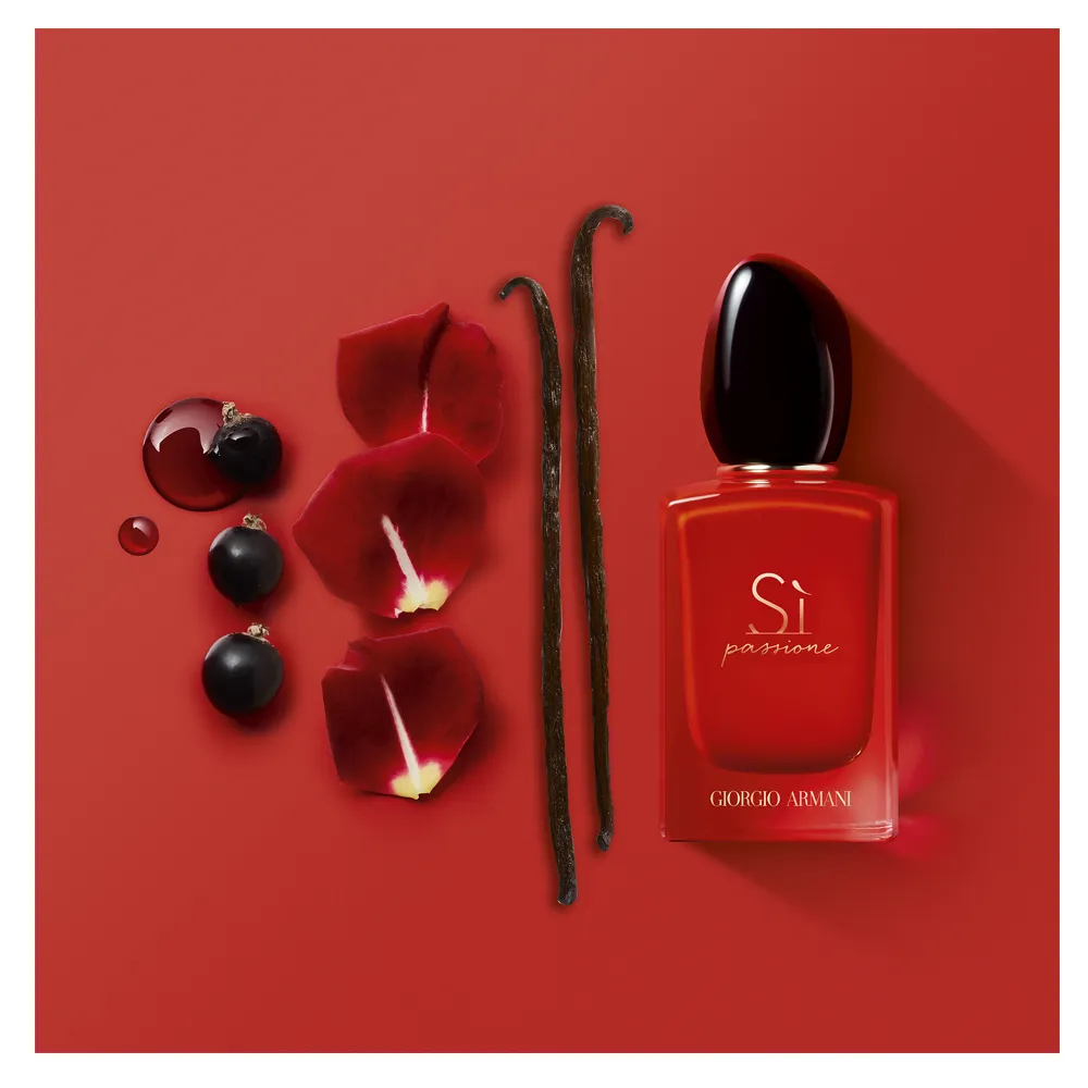 Frasco do perfume Giorgio Armani Sì Passione em destaque sobre fundo elegante, com iluminação suave que realça seu tom vermelho vibrante e detalhes dourados.