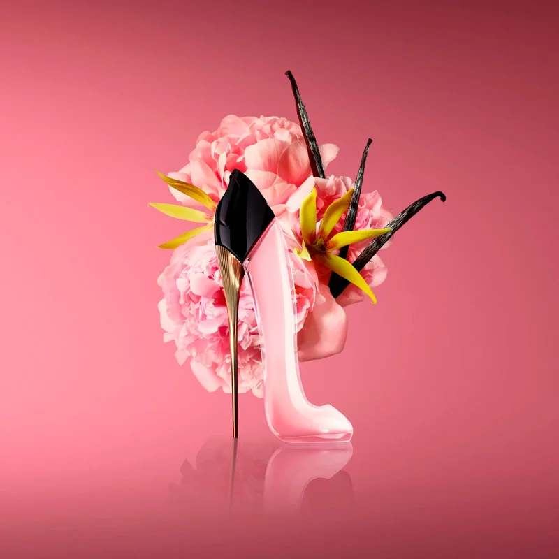 Frasco do perfume Good Girl Blush da Carolina Herrera em formato de stiletto rosa-claro com salto dourado, sobre fundo elegante e iluminação suave.