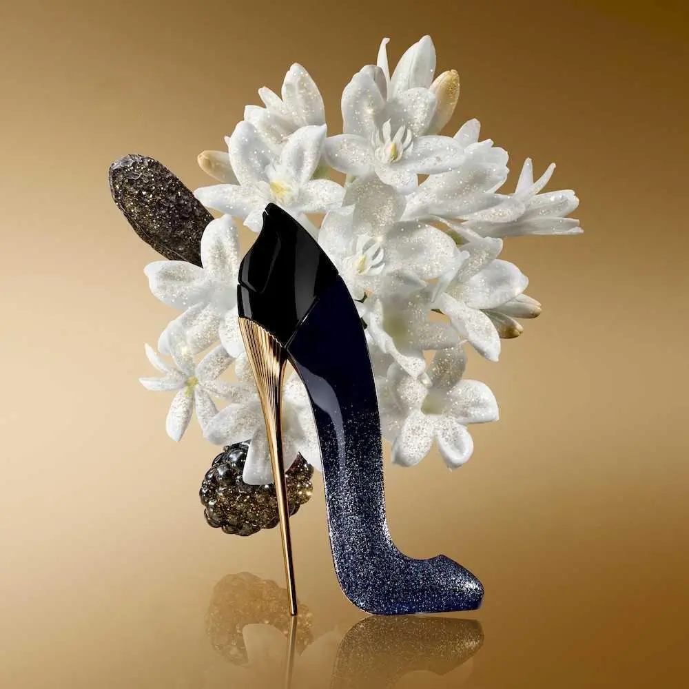 Frasco do perfume Carolina Herrera Good Girl Suprême em formato de stiletto preto com brilho, sobre fundo elegante e iluminação suave.