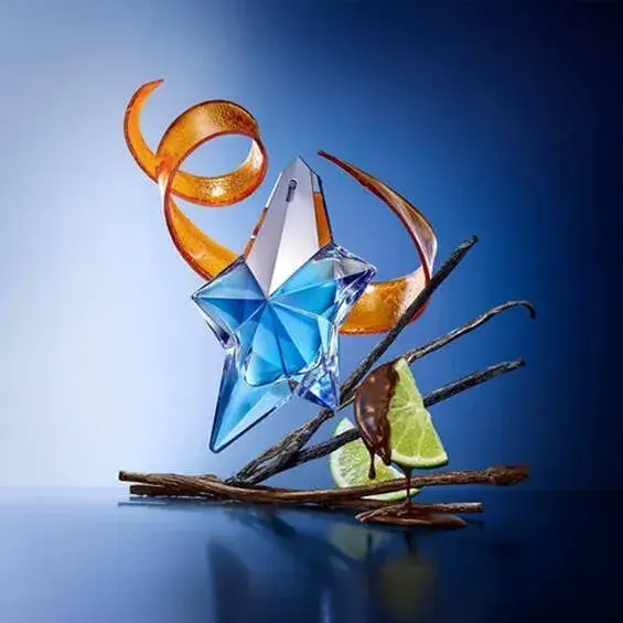 Frasco do perfume Angel Eau de Parfum de Thierry Mugler em destaque sobre fundo azul, rodeado por elementos visuais que representam suas principais notas olfativas: patchouli, baunilha, caramelo e frutas vermelhas.