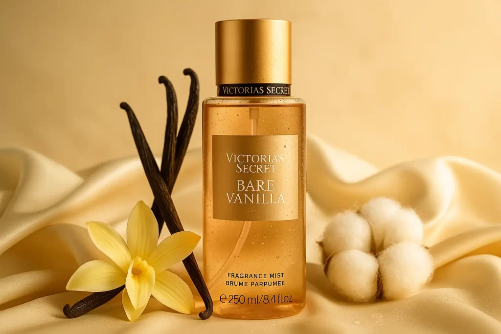 imagem horizontal do body mist Victoria’s Secret Vanilla (Bare Vanilla) sobre fundo claro, com favas e flor de baunilha e gotas que sugerem frescor; composição clean para artigo sobre fixação no calor