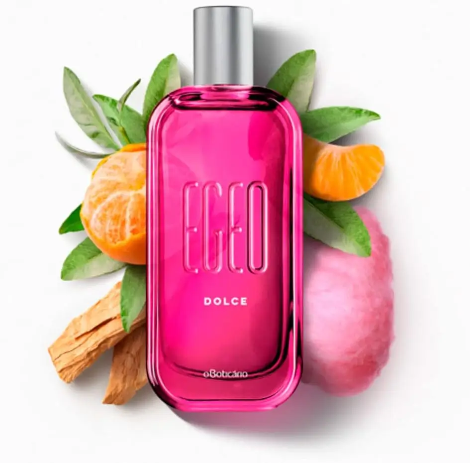 Frasco rosa do perfume Egeo Dolce, de O Boticário, com frutas e algodão-doce ao fundo
