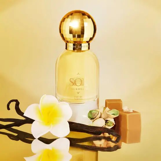 frasco original do Sol de Janeiro Cheirosa 62 Eau de Parfum com tampa dourada em “bola de disco”, iluminado por luz solar, remetendo ao acorde de pistache, caramelo salgado e baunilha.