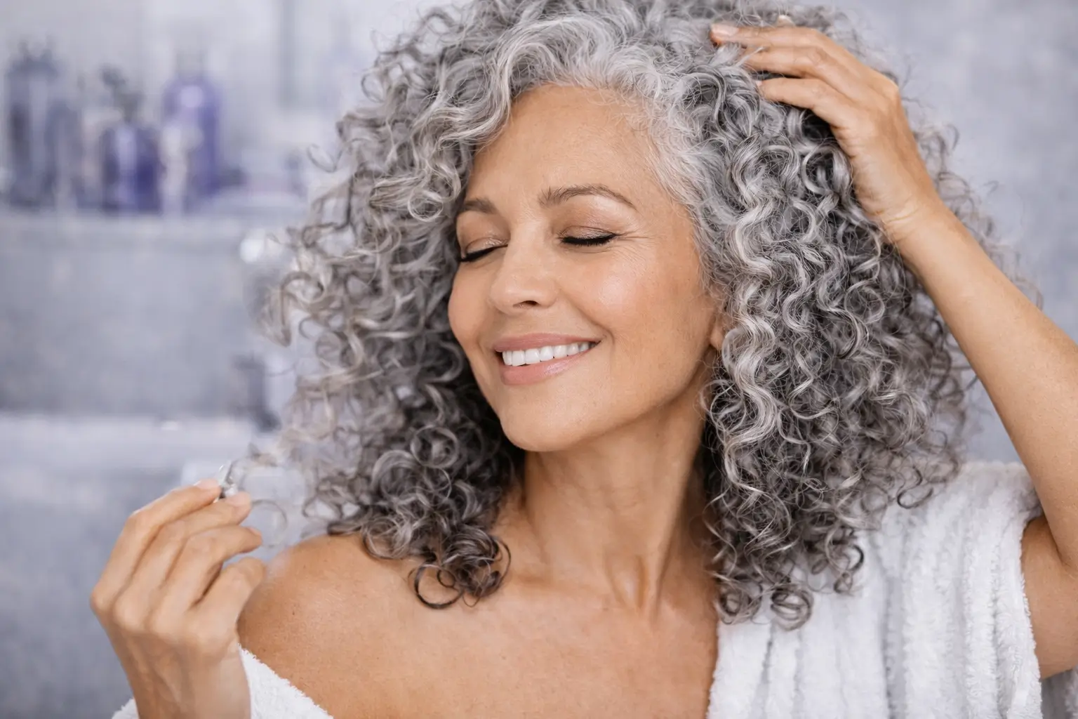 Mulher com cabelo cacheado grisalho brilhante e definido após matização